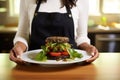 female chef presenting a black bean burger on a plate