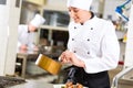 Female Chef in restaurant kitchen cooking Royalty Free Stock Photo