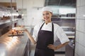 Female chef showing food dish to the camera in the commercial kitchen Royalty Free Stock Photo