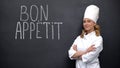 Female chef standing near Bon Appetite french phrase, advertise of elite kitchen