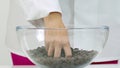 Female chef takes handful chocolate couverture callets from glass bowl slow mo