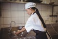 Female chef washing hands in the commercial kitchen Royalty Free Stock Photo