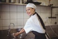 Female chef washing hands in the commercial kitchen Royalty Free Stock Photo