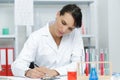 female chemist looking at test-tubes with blue liquids Royalty Free Stock Photo