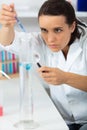 Female chemist mixes liquids in laboratory