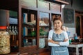 female chicken noodle seller in apron smiling with crossed arms