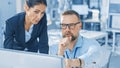 Female Chief Engineer Talks with Electronics Specialist, Explaining Things, He Works on Desktop Co Royalty Free Stock Photo