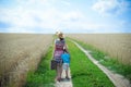 Female and child standing on road between field of