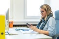 Female child therapist in an office during a phone call, using online calendar to schedule patients appointments. Calendar Planner