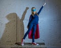 Female child 7 or 8 years old young girl performing happy and excited posing wearing cap and mask in super hero fantasy costume lo Royalty Free Stock Photo