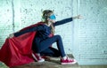 Female child 7 or 8 years old young girl performing happy and excited posing wearing cap and mask in super hero fantasy costume lo Royalty Free Stock Photo