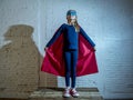 Female child 7 or 8 years old young girl performing happy and excited posing wearing cap and mask in super hero fantasy costume lo Royalty Free Stock Photo