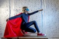 Female child 7 or 8 years old young girl performing happy and excited posing wearing cap and mask in super hero fantasy costume lo Royalty Free Stock Photo