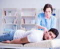 Female chiropractor doctor massaging male patient Royalty Free Stock Photo