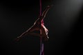 Female circus gymnast hanging upside down on aerial silk and demonstrates stretching. Woman performs tricks at height on Royalty Free Stock Photo