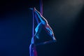 Female circus gymnast hanging upside down on aerial silk and demonstrates stretching. Young woman performs tricks at Royalty Free Stock Photo