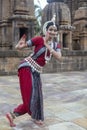 Female classical Odissi Dancer wears traditional costume with hand mudra at Mukteshvara Temple, Odisha, India