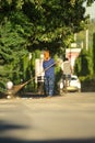 A female cleaner worker brooming or sweeping with a broom to the road of raipur at morning, Sweeper sweeping the road and cleaning Royalty Free Stock Photo