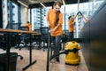 Female cleaning company team in overalls cleans and disinfects coworking space Royalty Free Stock Photo