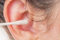 Female cleaning ear with cotton bud. Close up image. Hygiene concept.