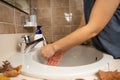 Female cleaning her hands in circular bathroom sink