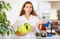 Female clerical worker holding rolled-up mat in hands