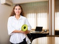 Female clerical worker holding rolled-up mat in hands