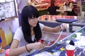 Female clerk threading and making gemstone necklace