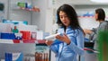 Female client analyzing pakages of vitamins on store shelves Royalty Free Stock Photo