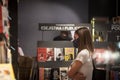 Female client, a girl, choosing a book in a bookstore wearing a respiratory face mask in Belgrade, during the coronavirus covid 19