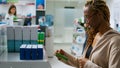 Female client looking at boxes of medicaments to cure disease