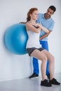 Female client working out with a ball during a training with a personal trainer Royalty Free Stock Photo