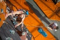 Female climber is climbing up on indoor rock-climbing wall Royalty Free Stock Photo