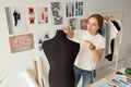 Female clothes designer taking dummy, mannequin measurements