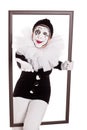 Female clown in a frame reaching hand to viewer Royalty Free Stock Photo
