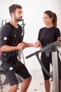 Female coach giving man ems electro muscular stimulation exerci