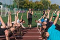 Female coach and group of children conducts a training session