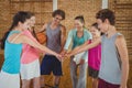 Female coach and high school kids with their hands stacked