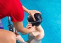 Female Coach In Water Giving preteen boy swimming Lesson In Indoor Pool Royalty Free Stock Photo