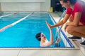 Female Coach In Water Giving preteen boy swimming Lesson In Indoor Pool Royalty Free Stock Photo