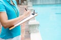 Female coach writing on clipboard near poolside Royalty Free Stock Photo