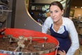 Female coffee factory employee checking roasting process Royalty Free Stock Photo