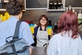 Female coffee shop worker serving customers giving paper cups of takeaway coffee