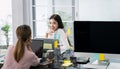 Female colleagues are talking, consulting or gossiping at the Home Office. Two young women sitting at the opposite desk chatted Royalty Free Stock Photo