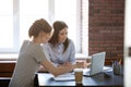 Female colleagues working together with laptop using corporate s Royalty Free Stock Photo