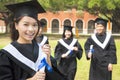 Female college graduate with classmates and holding a diploma Royalty Free Stock Photo