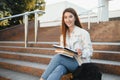 Female college student with books outdoors. Smiling school girl with books standing at campus. I'm prepared for exam Royalty Free Stock Photo