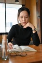 Female college student focused and concentrated reading a textbook