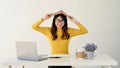 A female college student is putting a book on her head while sitting at her desk Royalty Free Stock Photo