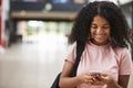 Female College Student Reading Text Message On Mobile Phone